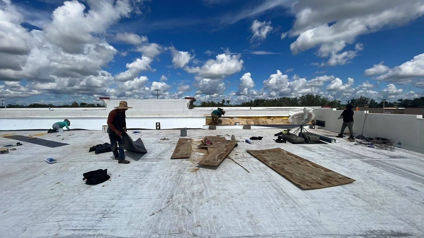 Crew tearing off an old commercial flat roof